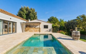 A modern house with a swimming pool, a stone wall, and a small garden. - VILLA PROVENÇALE AVEC PISCINE (Montauroux)
