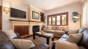 A living room with a fireplace, a television, and a sofa. - House in Alcudia Bell Lloc with pool near the sea (Alcúdia)