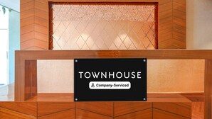 Vastaanottotiski, jossa on kyltti, jossa lukee: ”TOWNHOUSE” ja ”Yrityksen palvelut”.