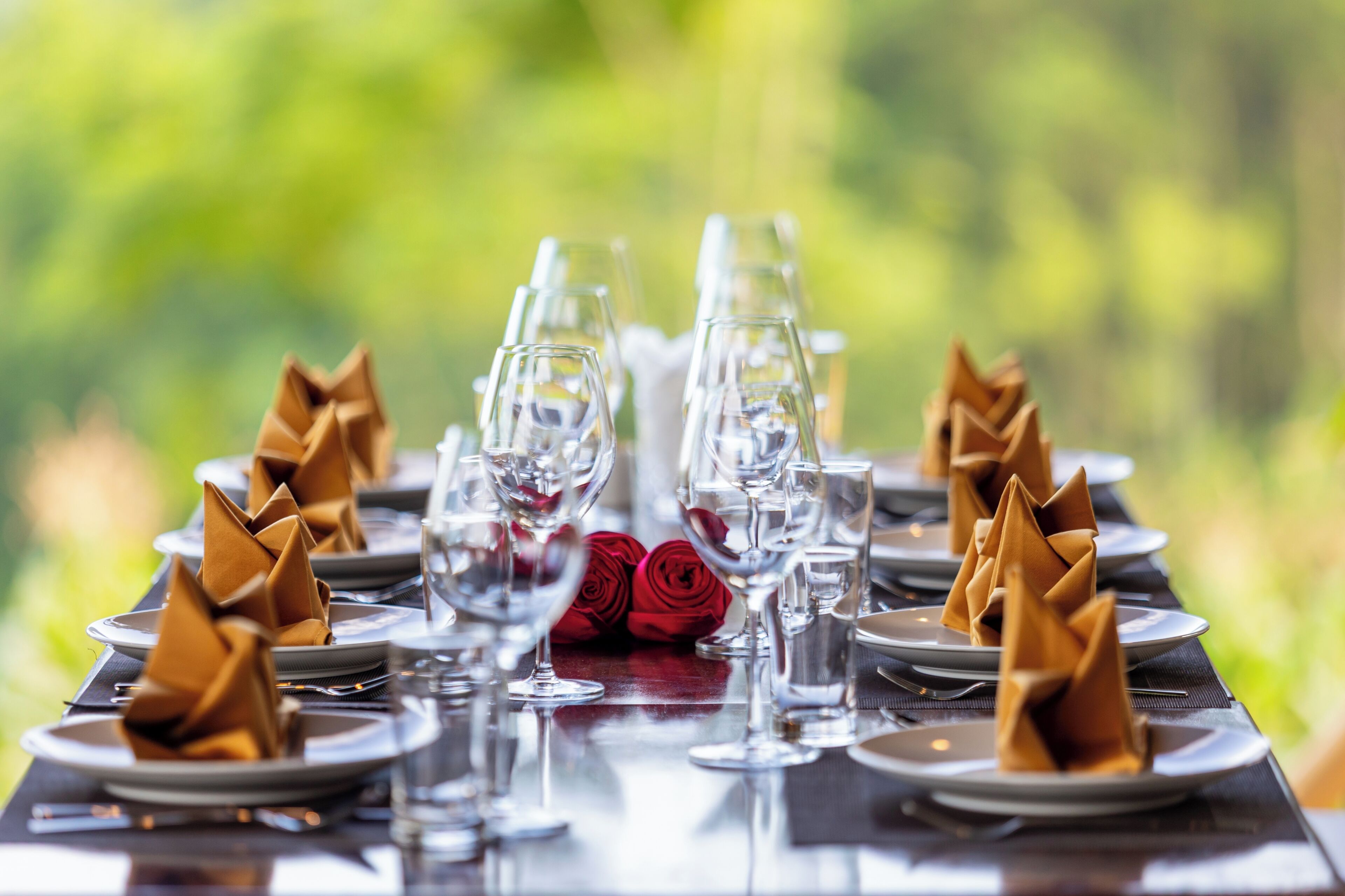 A table set for a meal with clear glassware and folded napkins.