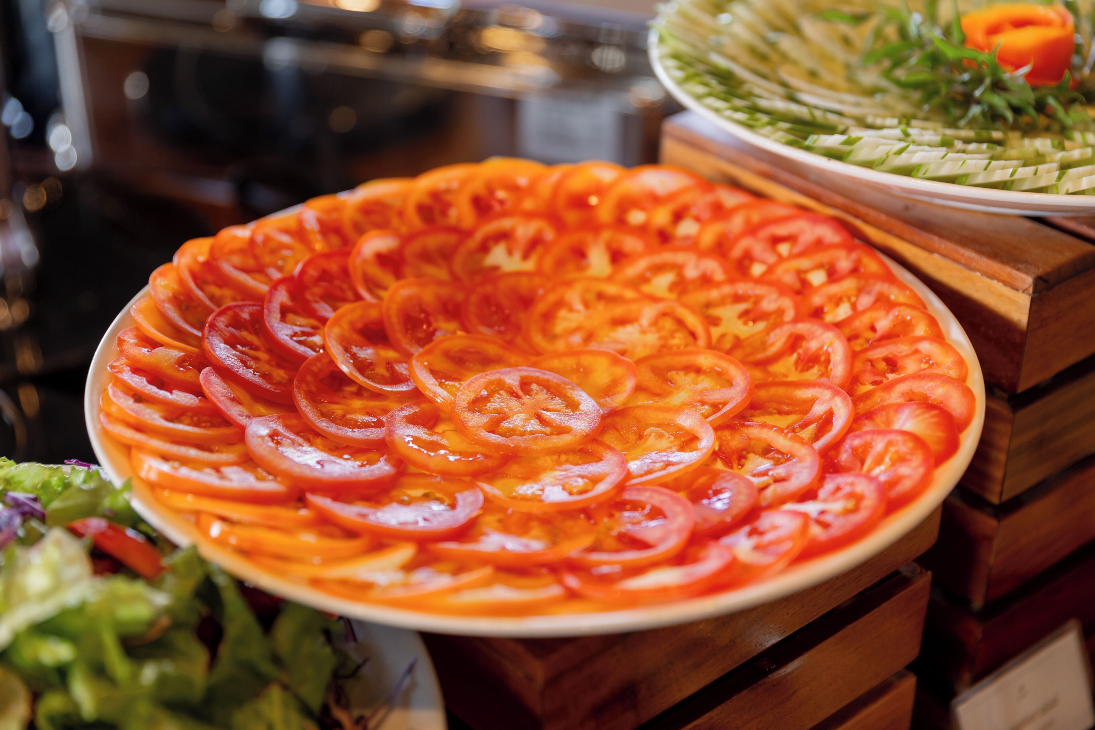 A pizza with tomato slices arranged in a circular pattern.