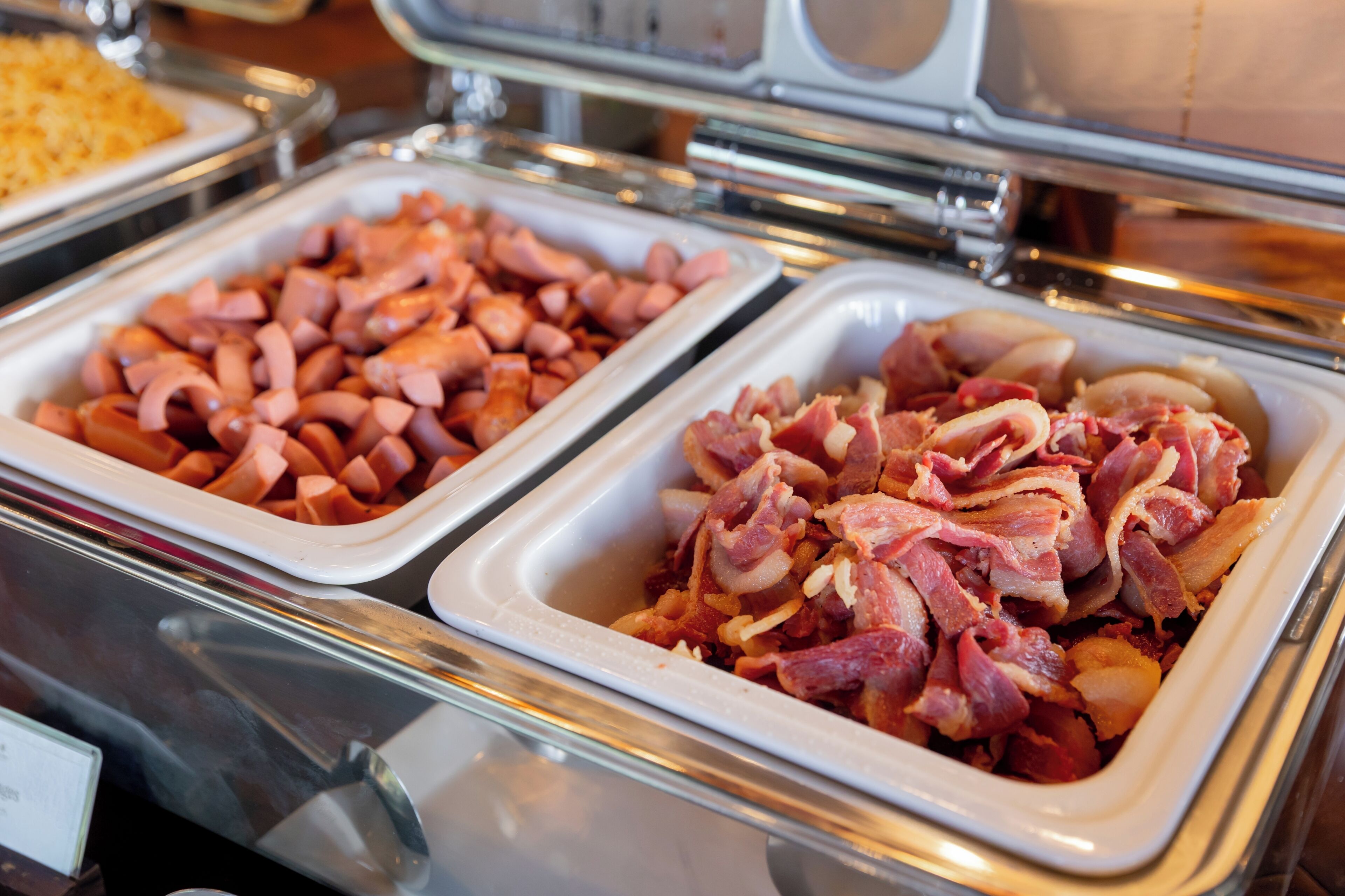 Ein reichhaltiges Buffet mit verschiedenen Speisen, darunter Schinken und Wurst.