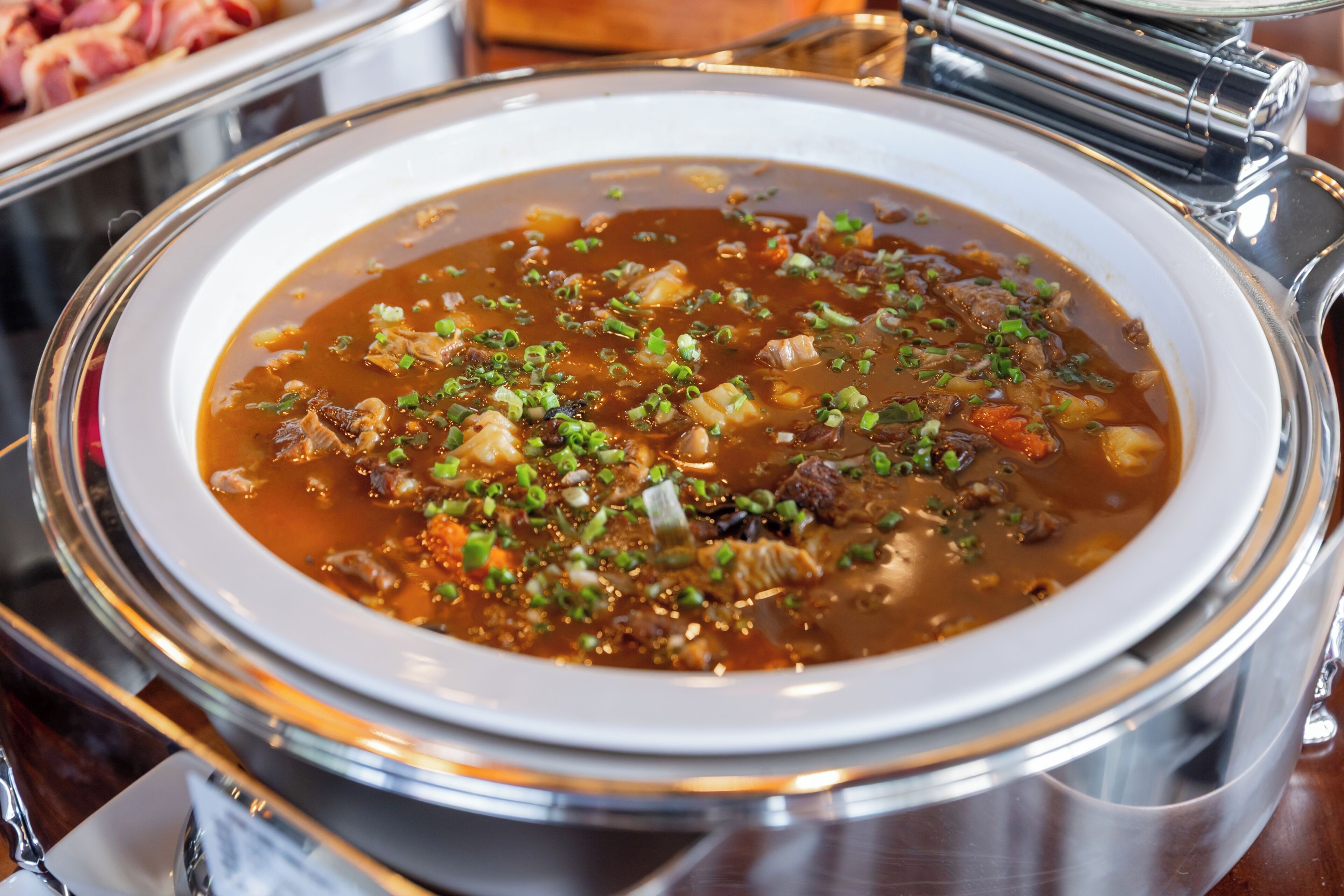 Un tazón de sopa con tapa sobre una mesa.