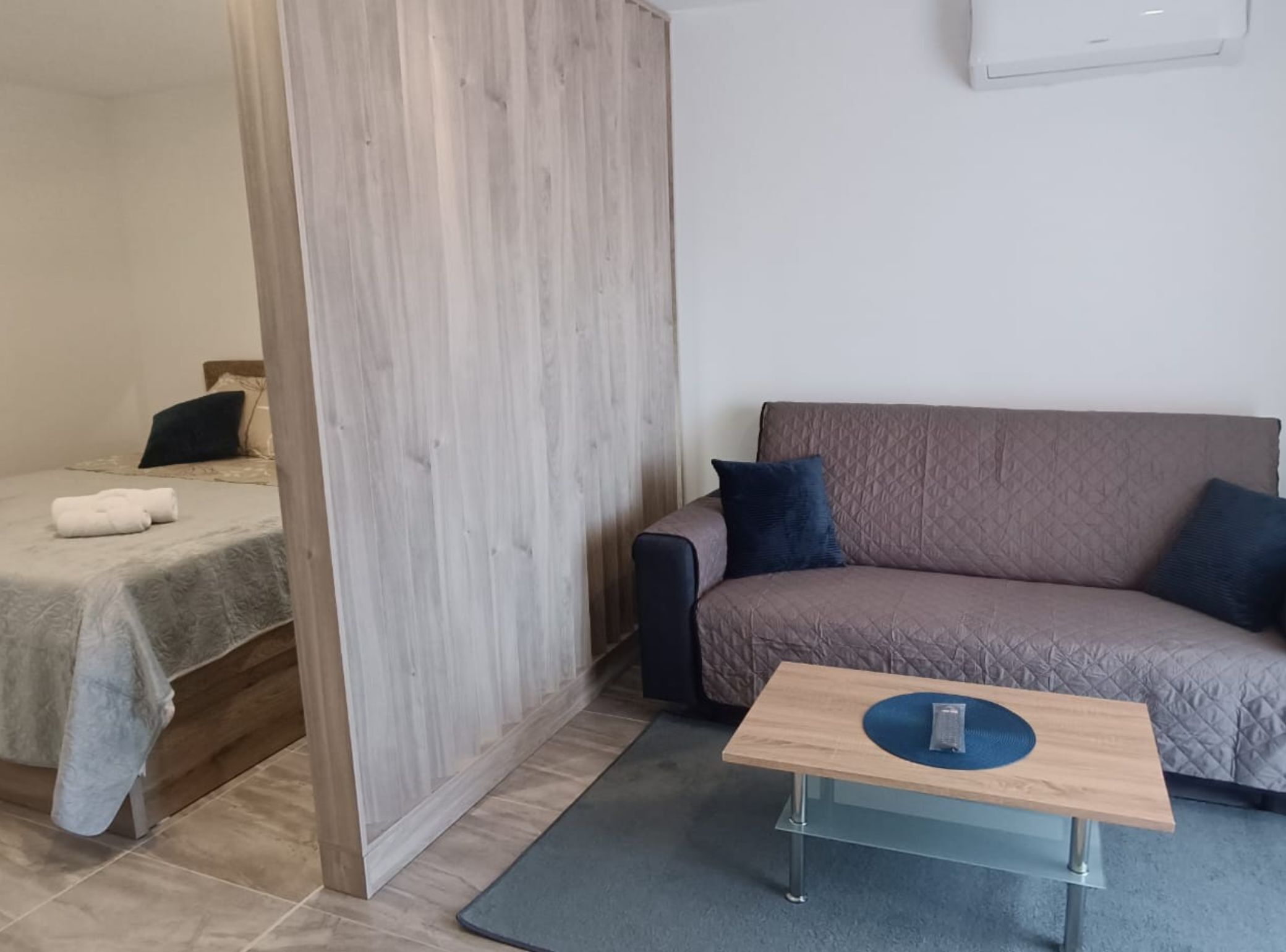 Ein modernes Zimmer mit einem Bett, einer Schlafcouch und einem kleinen Tisch.