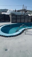 Una piscina al aire libre de temporada, sillones reclinables de piscina
