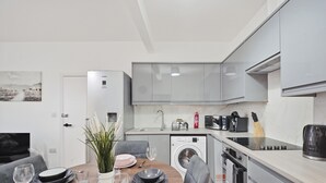 Cocina compacta con lavadora, microondas y tostadora.