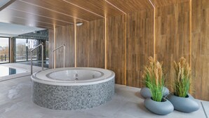 A modern spa area with a hot tub, wooden walls, and potted plants. - Apartamenty Sun & Snow The One Ustronie Morskie (Sianożęty)