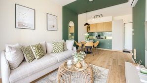 A living room with a sofa, coffee table, and artwork on the wall. - Apartamenty Sun & Snow The One Ustronie Morskie (Sianożęty)