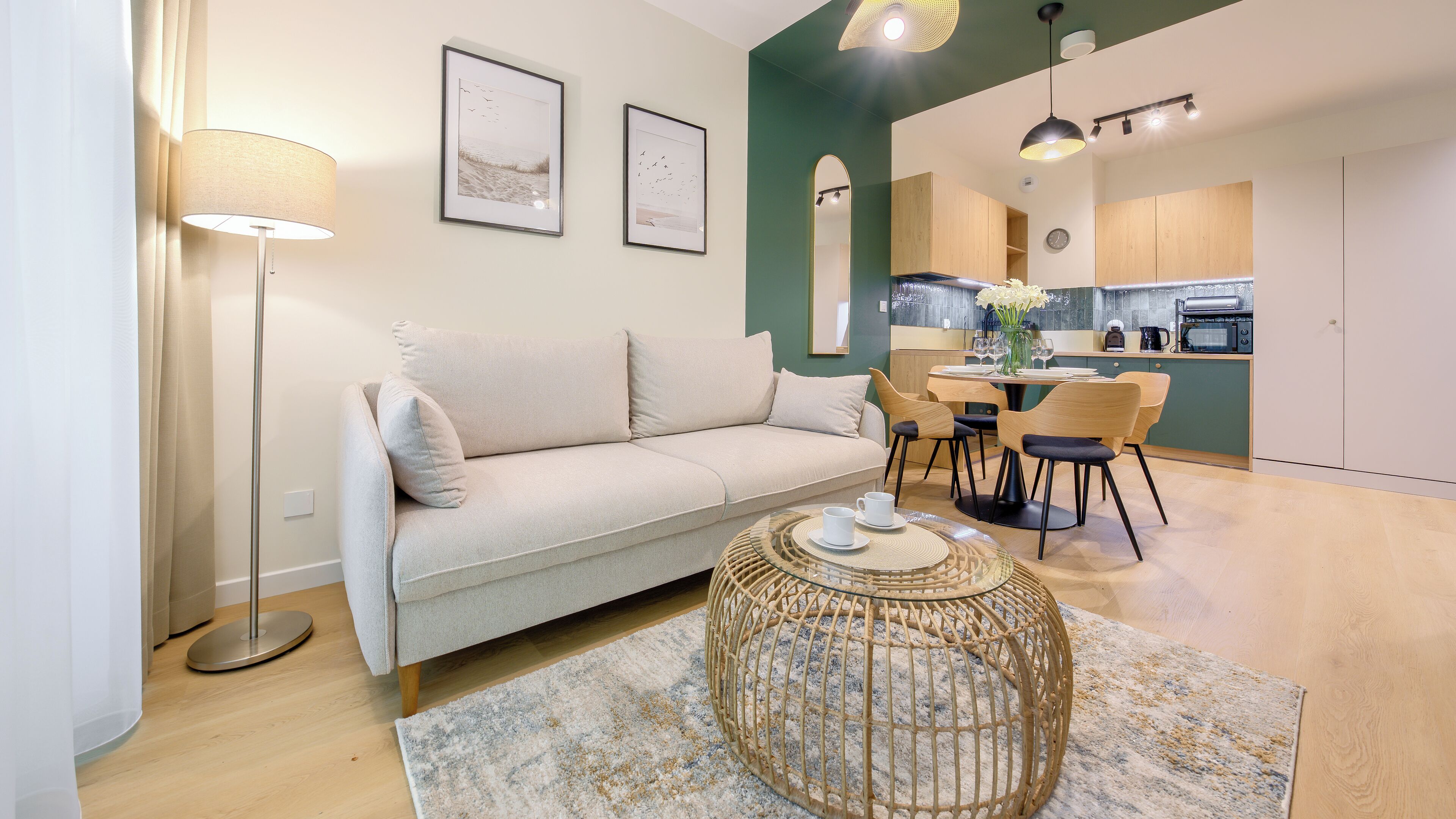 Una sala de estar moderna con un sofá, una mesa de centro redonda y un comedor con sillas.