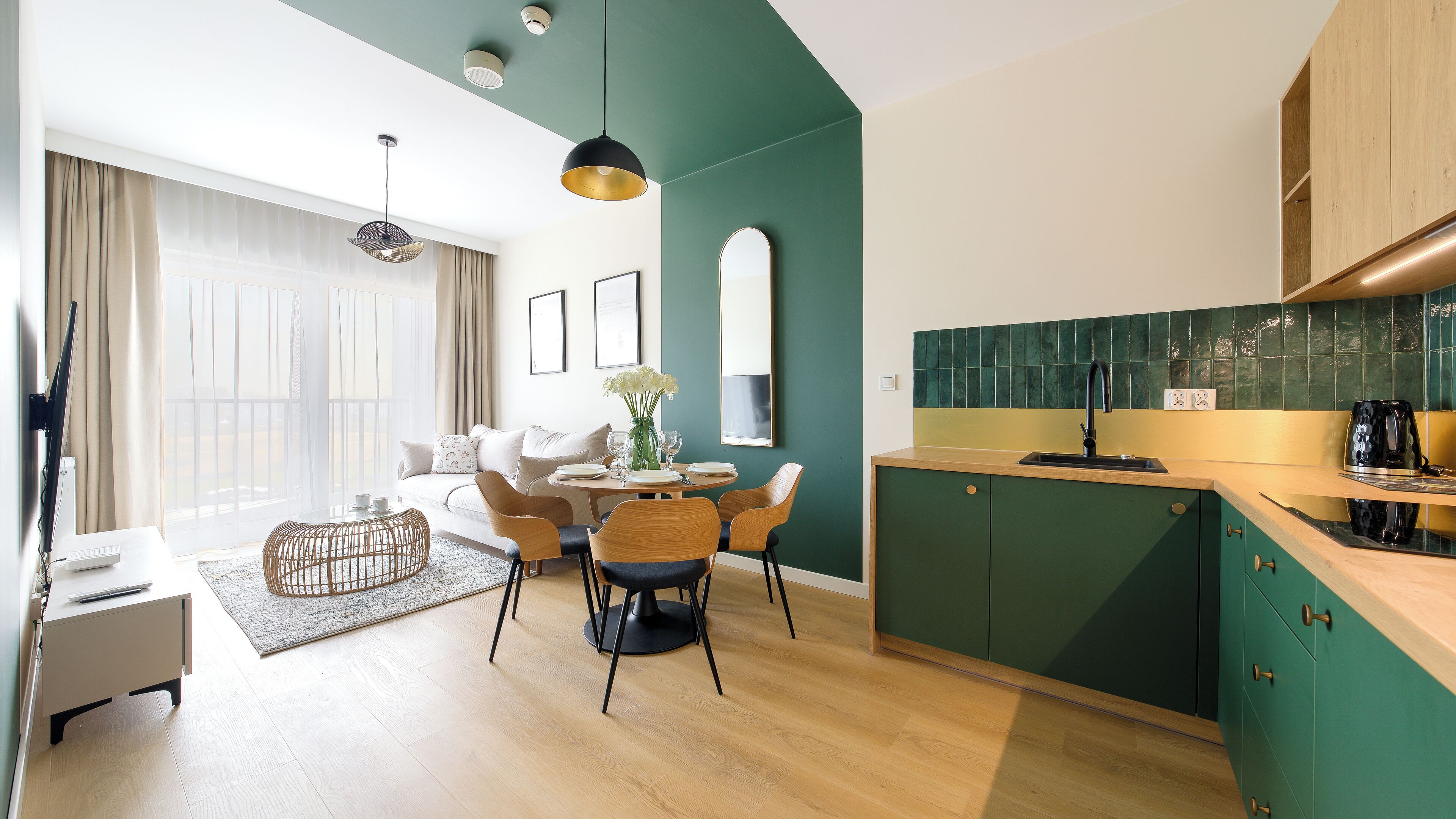 A modern apartment with a dining area, kitchen, and living space.