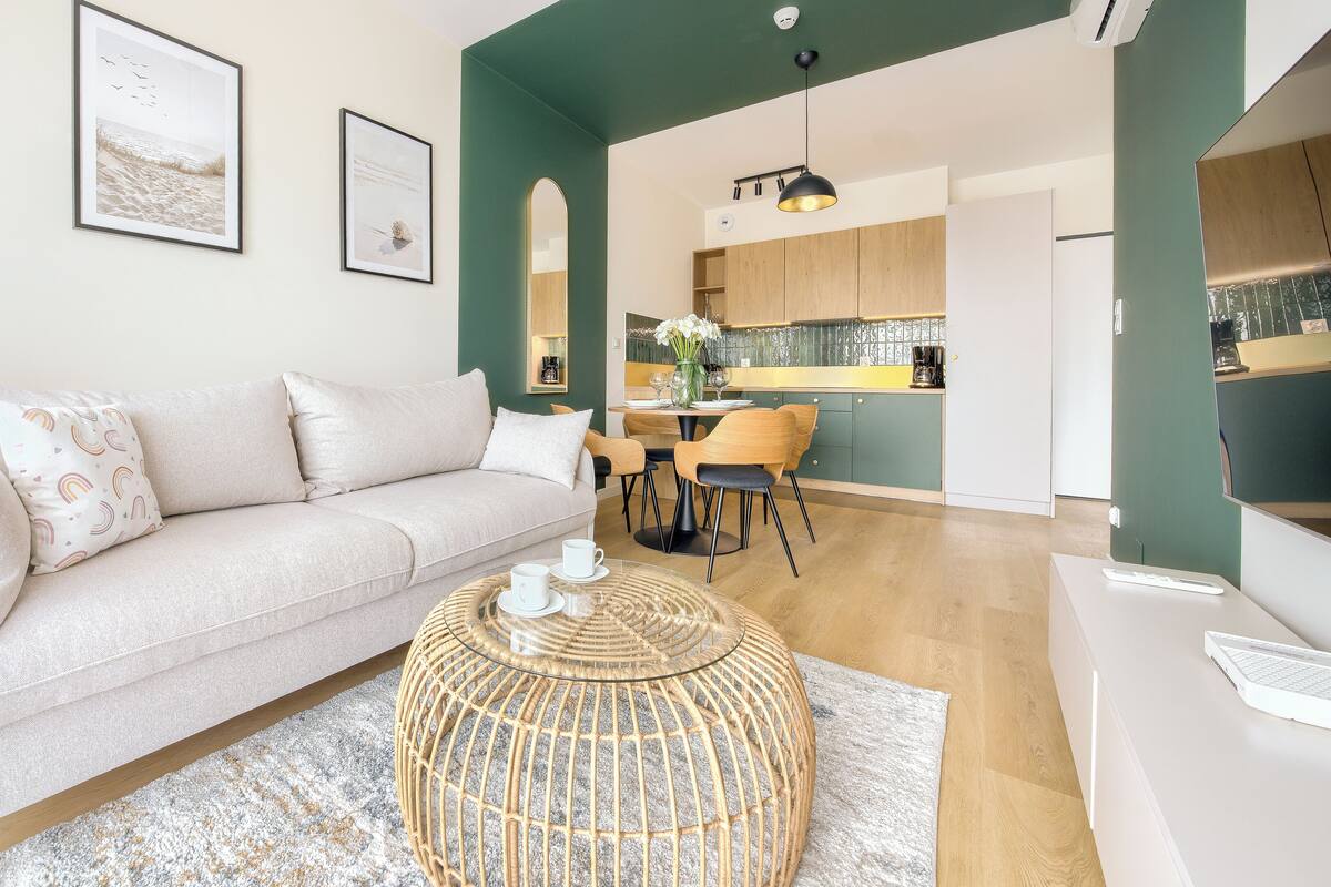 Ein modernes Wohnzimmer mit einer Couch, einem Couchtisch und gerahmten Kunstwerken an der Wand.