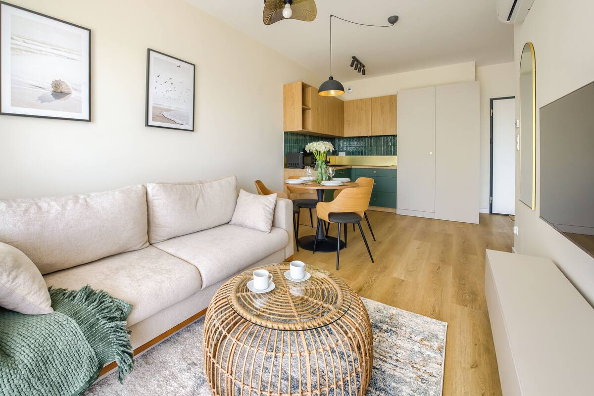 Ein modernes Wohnzimmer mit einer Couch, einem Couchtisch und einem Essbereich mit Stühlen.