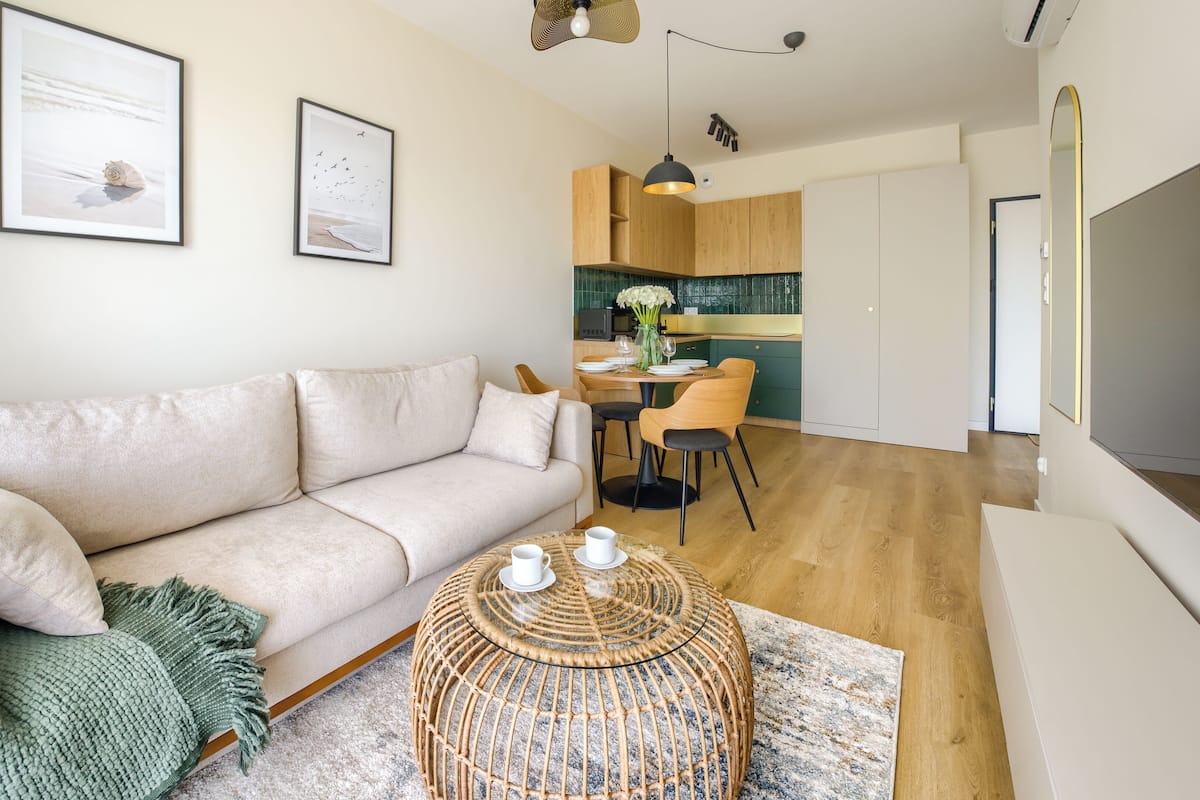 Una sala de estar moderna con un sofá, una mesa de centro y una zona de comedor con sillas.