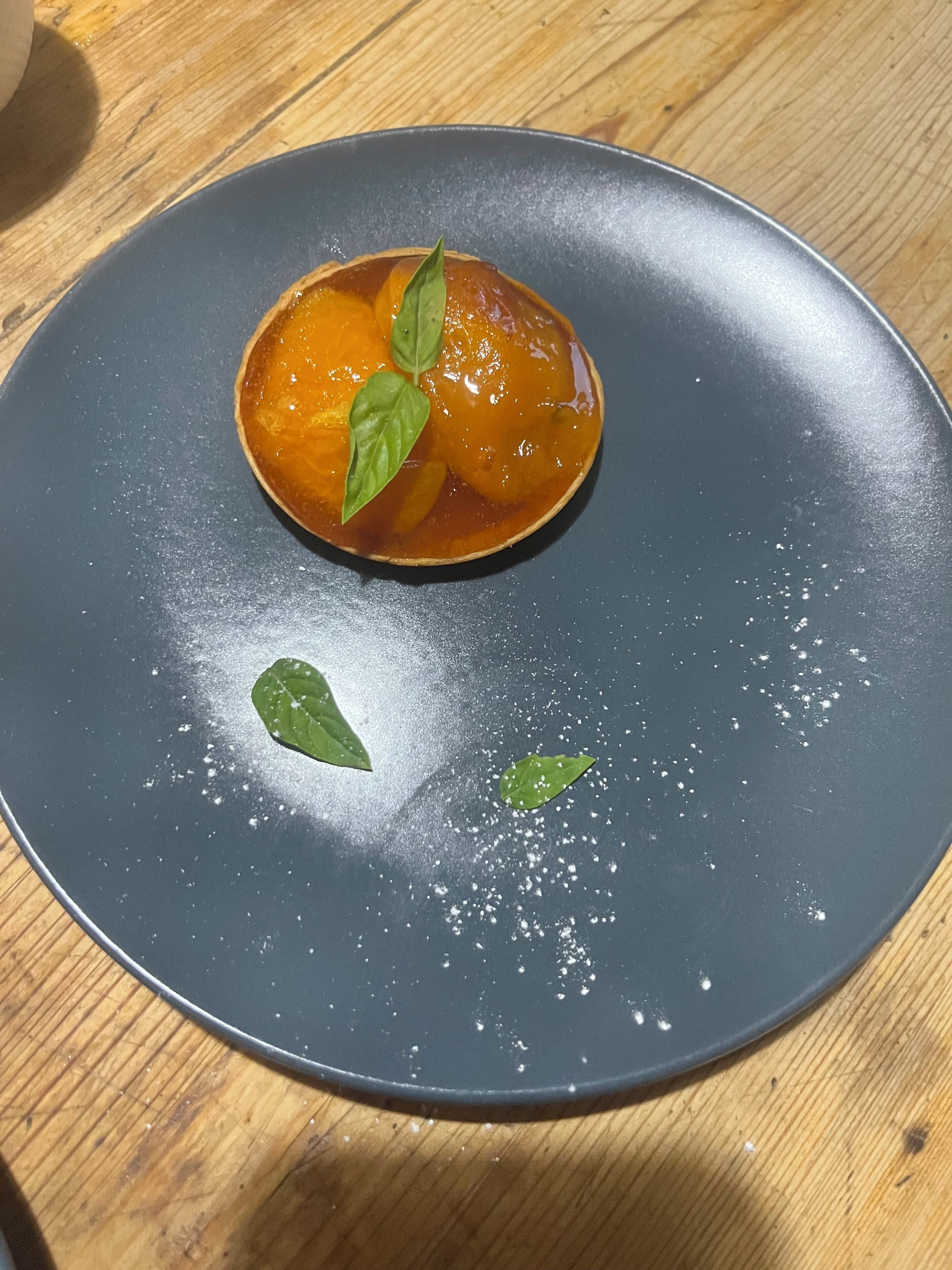 A dessert on a dark plate with a wooden table background.