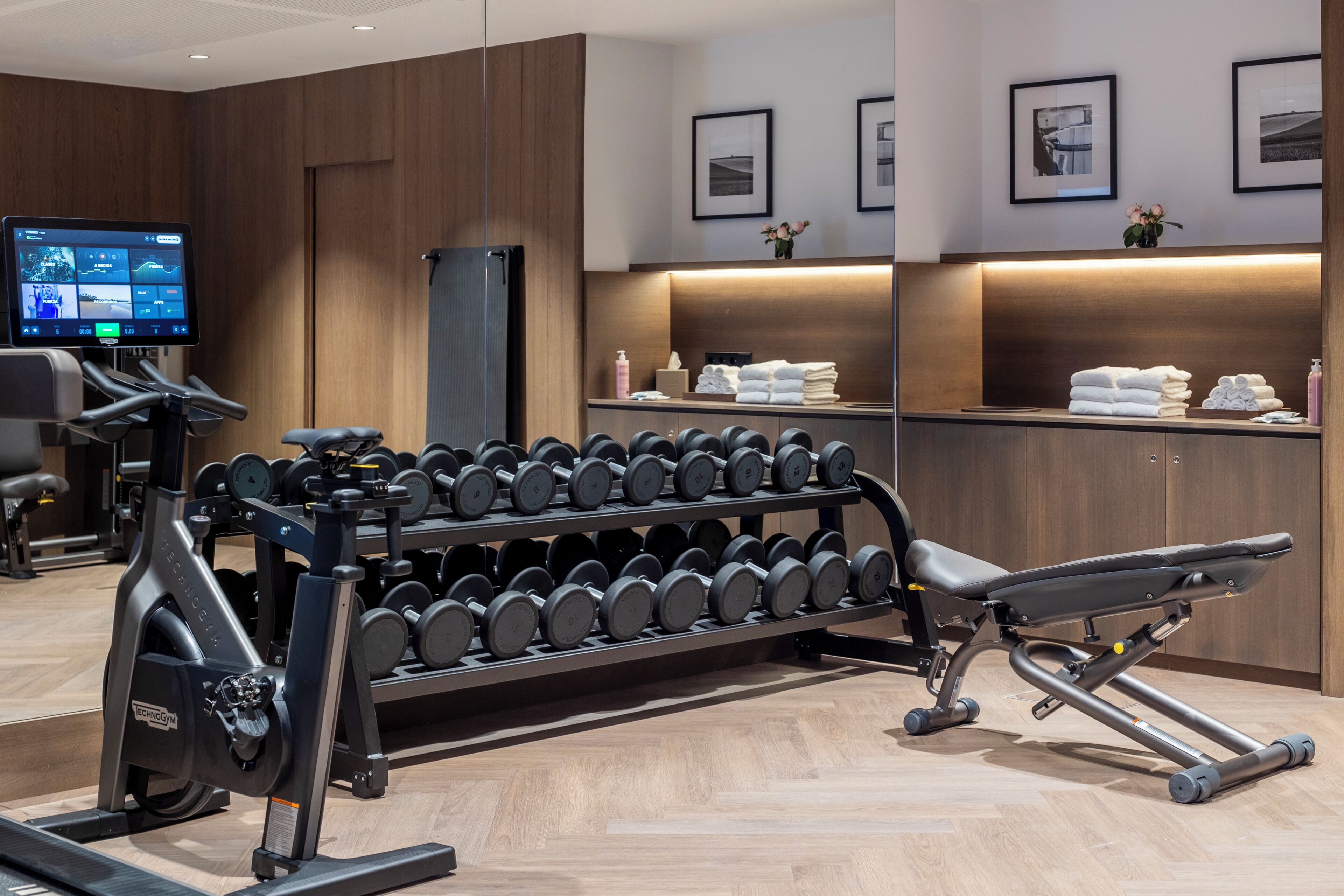 A gym with exercise equipment, a television, and a mirror.