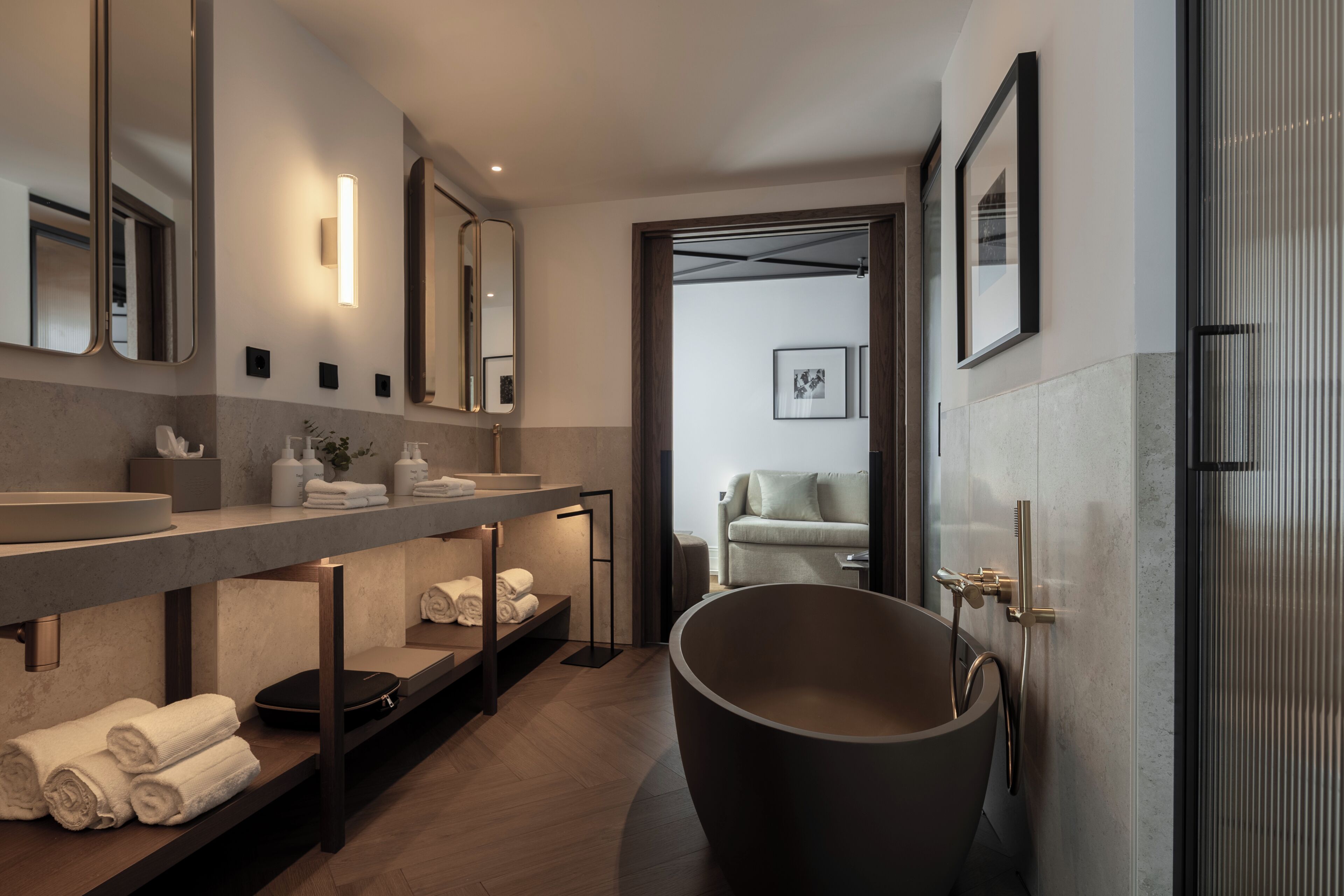 A modern bathroom with a freestanding bathtub, a large mirror, and a vanity with a countertop.