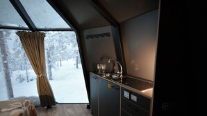 Eine kleine Küche mit Fenster, Spüle und einer Arbeitsplatte.