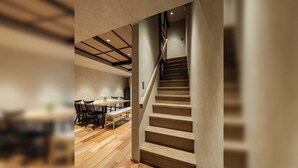 Ein modernes Interieur mit Treppe, Holzböden und einem Essbereich mit Stühlen und Tisch.