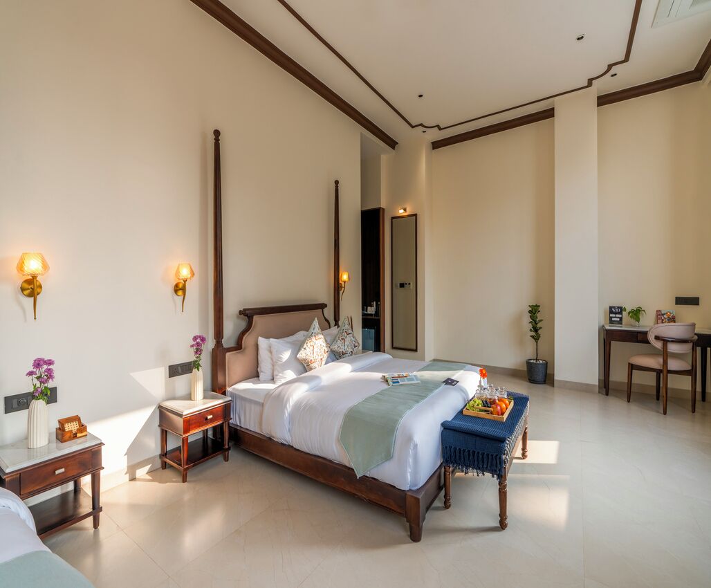 Une chambre spacieuse avec un grand lit, des tables de chevet, un bureau et une chaise.