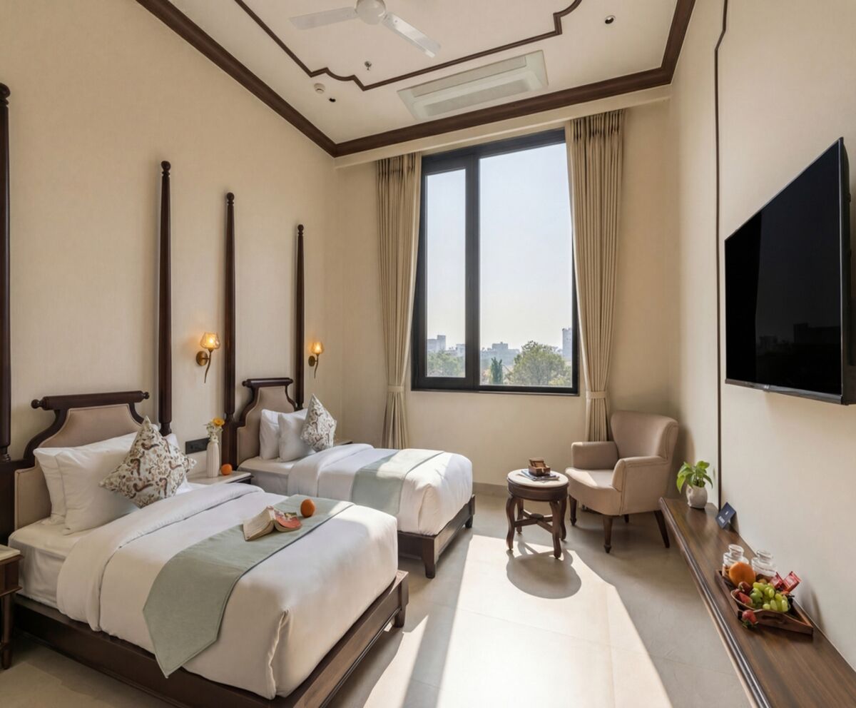 Een hotelkamer met twee bedden, een televisie, een klein tafeltje met fruit, en uitzicht op de stad.