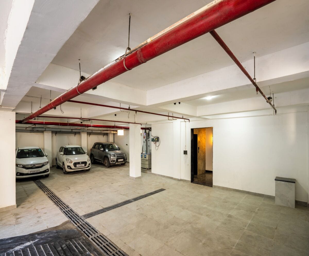Un parking où trois voitures sont garées sur la première rangée.