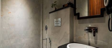 A modern bathroom with a shower, toilet, and sink.