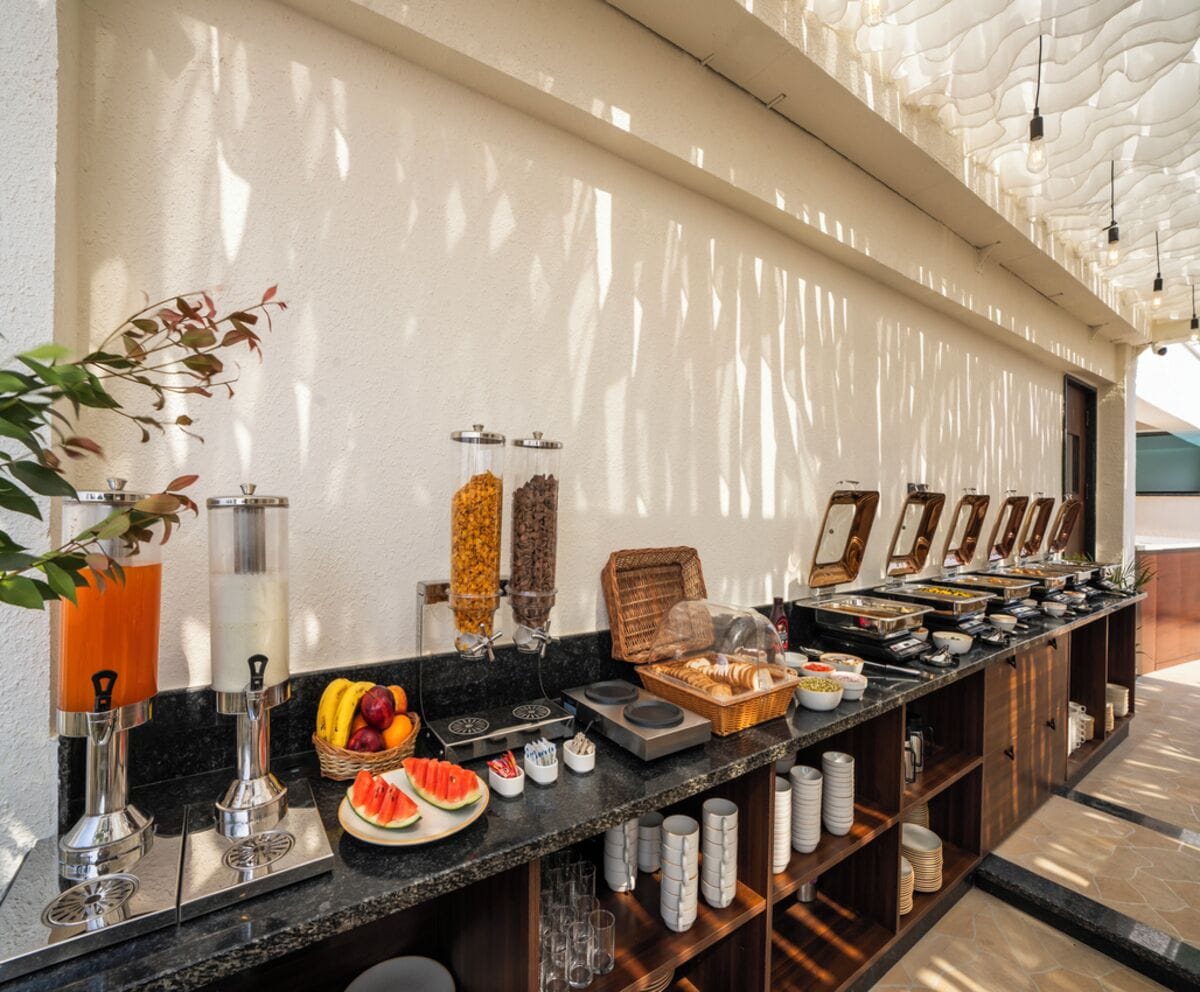 A buffet setup with various food items and drink dispensers.