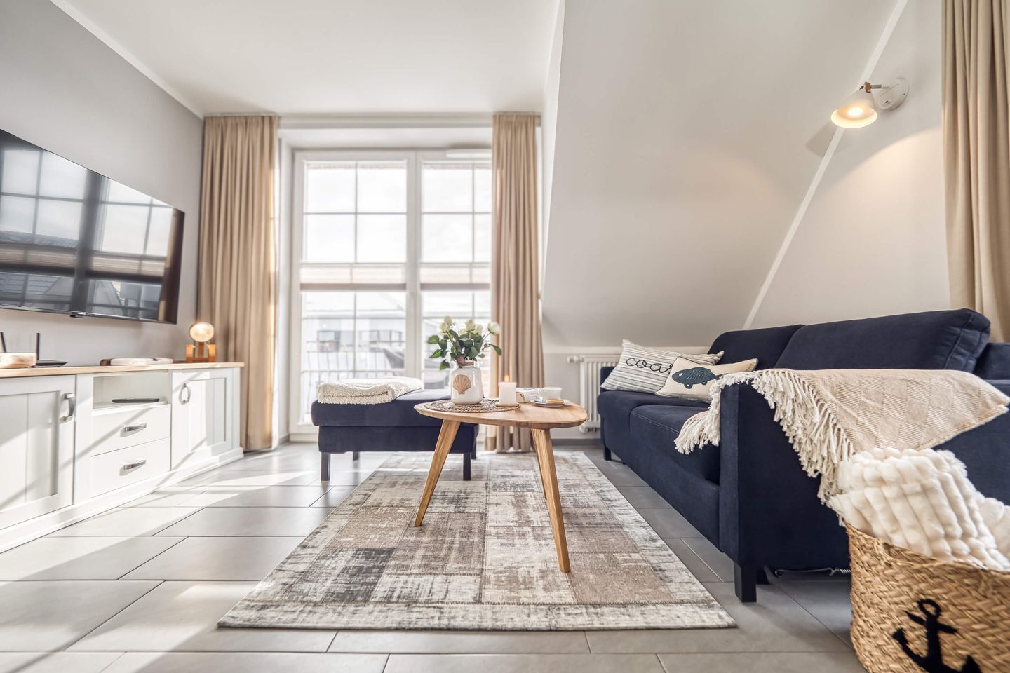 Ein modernes Wohnzimmer mit Sofa, Couchtisch und Fernseher.