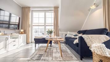 Ein modernes Wohnzimmer mit Sofa, Couchtisch und Fernseher.
