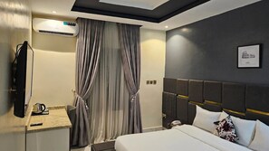 Habitación Deluxe, balcón, vista a la ciudad | Escritorio, espacio para trabajar con laptop y cortinas blackout 