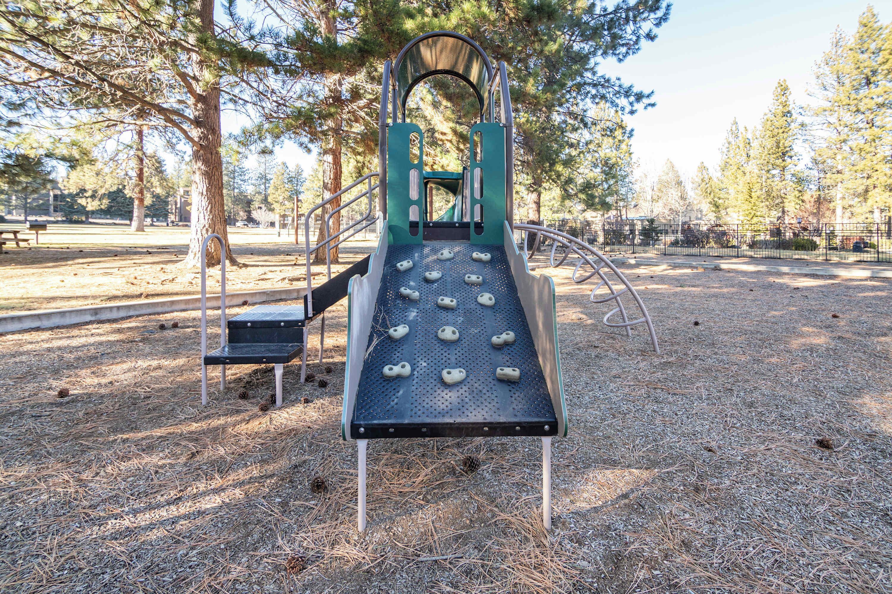 Un parque infantil con un tobogán y una estructura para escalar.