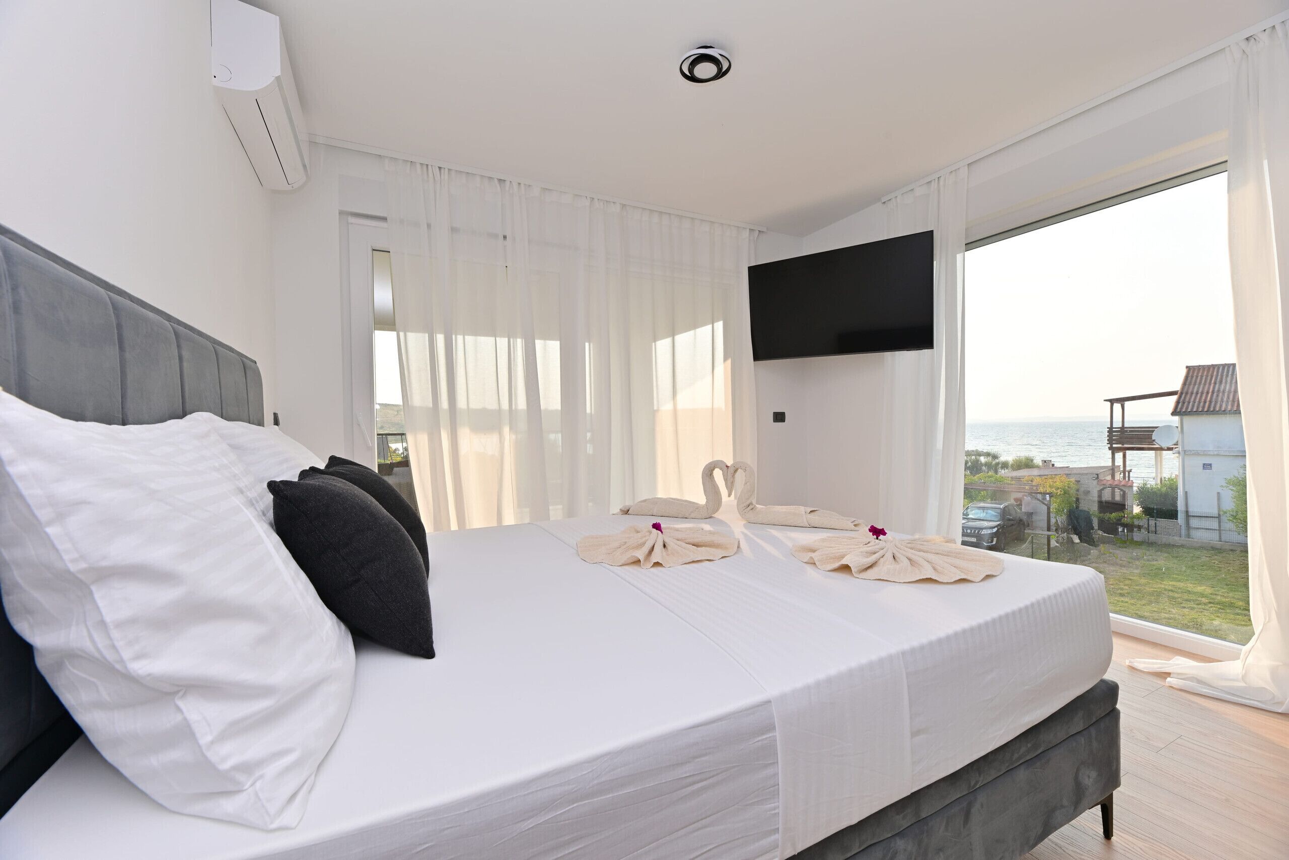 Quarto de hotel com cama, televisão de tela plana e vista para o mar.