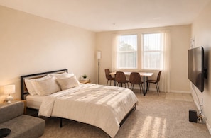A bedroom with a bed, bedside table, lamp, and a TV mounted on the wall. - Marina & Venice Beach Getaway (Marina del Rey)