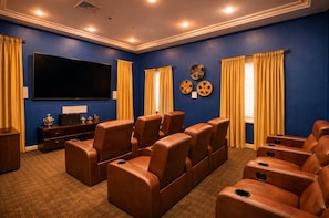A home theater room with a large flat-screen TV, leather reclining chairs, and a carpeted floor. - Marina & Venice Beach Getaway (Marina del Rey)