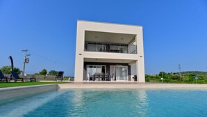 A modern two-story building with a swimming pool in front. - Villa Giovanni Zadar Villas (Razanac)