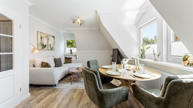 Un loft modern amb zona de menjador, sofà i vistes a la vegetació.