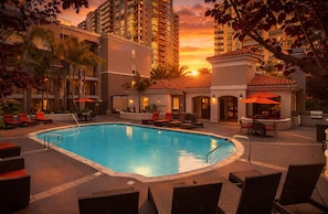 A swimming pool surrounded by lounge chairs and umbrellas, with tall buildings in the background. - 1 Bedroom 1 Bathroom Marina Del Rey Unit (Marina del Rey)
