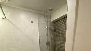 Une salle de bain moderne avec une douche à parois de verre, des toilettes blanches et un bidet.