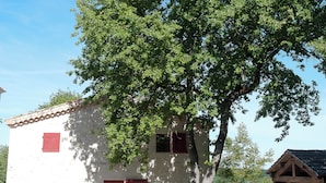 A white building with red shutters and a stone wall. - Gîte Petite Maison in the Gers countryside (Castelnau-sur-l'Auvignon)
