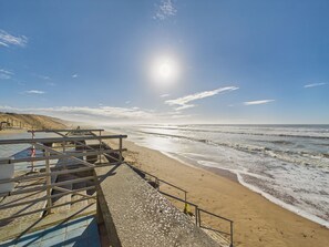 A beach with a wooden walkway leading to a lifeguard tower. - Accommodation for 4 with magnificent sea view (Saint-Gilles-Croix-de-Vie)