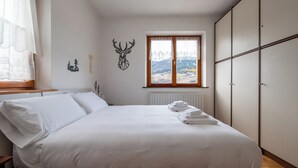 Ein Schlafzimmer mit Bett, Fenster und Heizkörper.