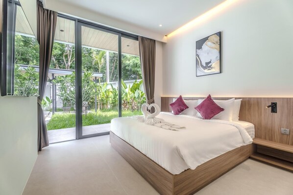 A modern bedroom with a large bed, a view of greenery through sliding glass doors, and a minimalist decor. - Aileen Layan Villa 6/ 4BR Forest/ 2 Minutes Beach (Choeng Thale)
