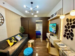 Design appartement, balkon, uitzicht op zwembad | Woonruimte | Een 50-inch smart-tv met digitale zenders, Netflix en streamingdiensten