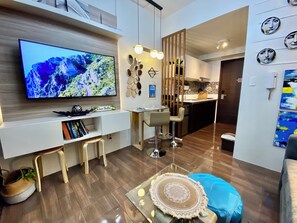 Design Condo, Balcony, Pool View | Living area | 50-inch Smart TV with digital channels, Netflix, streaming services - Smdc Air Residences (Makati)