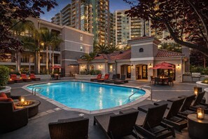 Ein Poolbereich mit Liegestühlen, einer Bar und einem Pool.