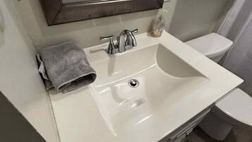 Een haardroger, handdoeken, shampoo, toiletpapier