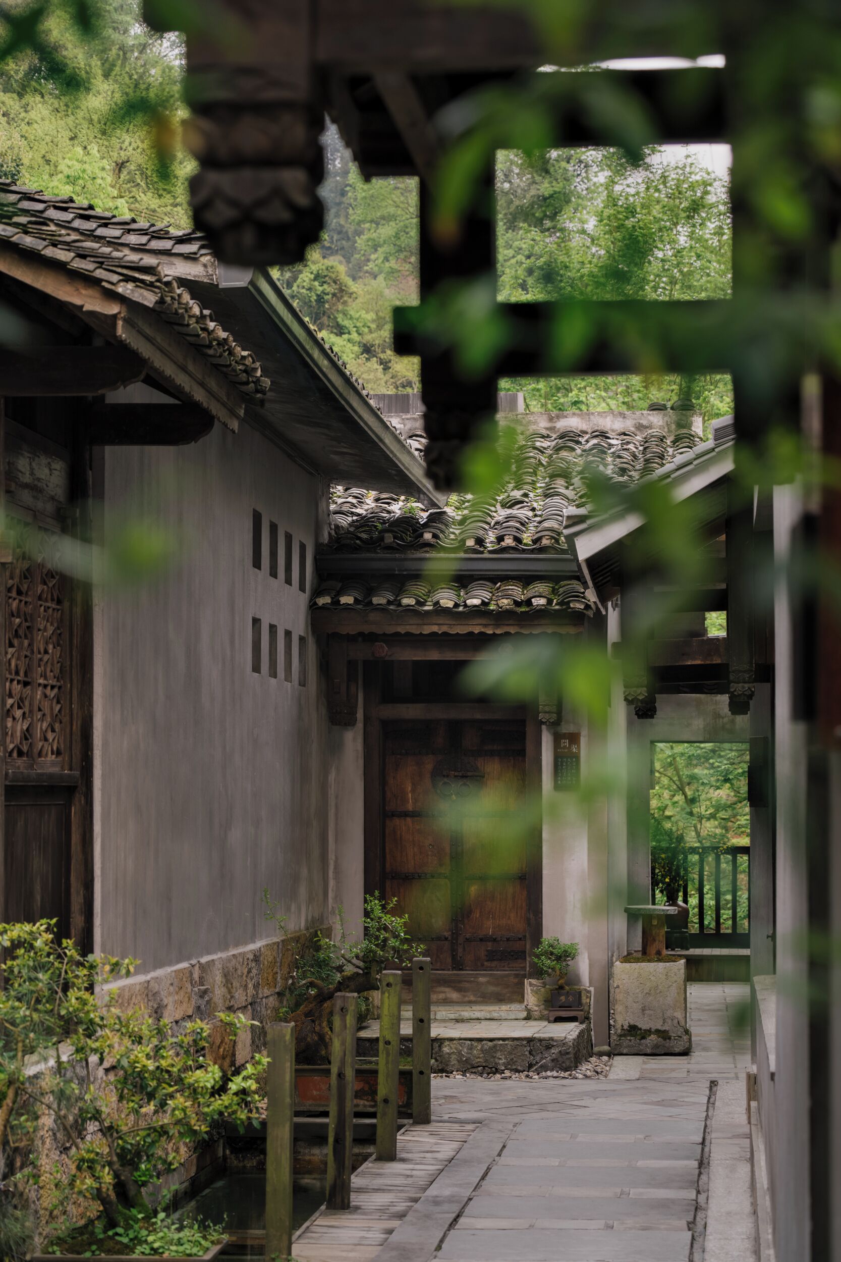 Il s’agit d’un bâtiment japonais traditionnel, avec une façade en bois, un toit recouvert de tuiles et un chemin de pierre menant à une porte en bois.