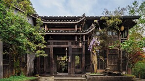 A traditional building with a tiled roof, wooden gates, and a stone lantern. - Fanjingshan Ansu Homestay (Tongren)