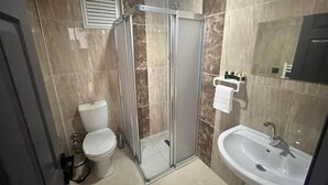 Une salle de bain moderne avec une douche à parois de verre, des toilettes et un lavabo.