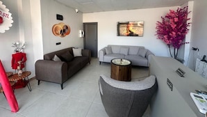 Un salon moderne avec deux canapés, une table basse et une plante décorative.